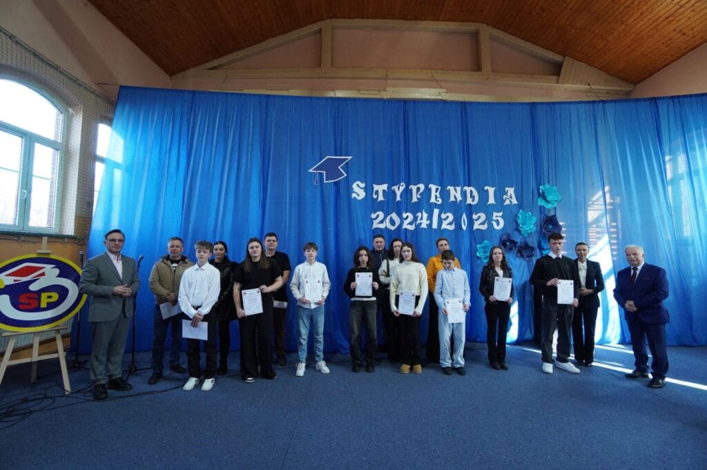 Grupa studentów z dyplomami na ceremonii stypendialnej