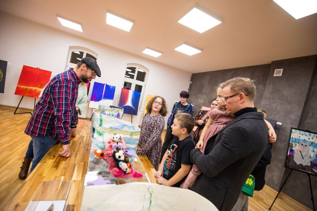 Grupa ludzi ogląda ekspozycje w galerii sztuki