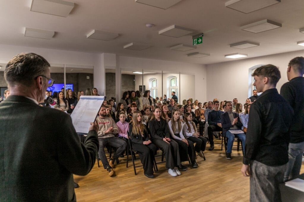 Mężczyzna prezentuje przed publicznością w sali konferencyjnej