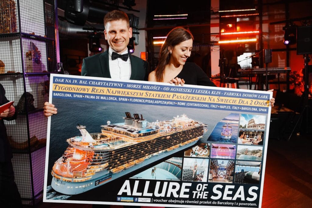 Para trzymająca plakat rejsu na Allure of the Seas